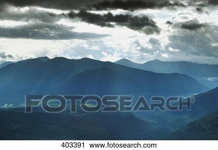 Stock Image - Sun shining mountains. Fotosearch