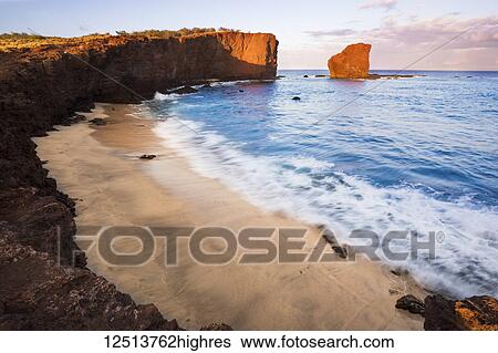 Stock Photograph - Sunset light on the clouds above Puu Pehe Rock at sunset, also known as 'Sweetheart Rock', one of Lanai's most recognizable landmarks; Lanai, Hawaii, United States of America. Fotosearch
