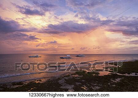 Stock Photograph - Sunset Over The Ocean With Pump Boats; Anda, Bohol, Central Visayas, Philippines. Fotosearch