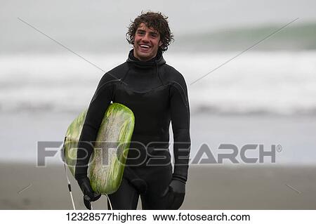 Surfer holding board along coast near Yakutat, Southeast Alaska; Alaska, United States of America View Large Photo Image Stock Photograph - Surfer holding board along coast near Yakutat, Southeast Alaska; Alaska, United States of America. Fotosearch