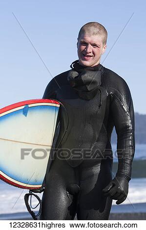 Surfer in a wetsuit holding surfboard while on the Kenai Peninsula Outer Coast, South-central Alaska; Alaska, United States of America View Large Photo Image Stock Photograph - Surfer in a wetsuit holding surfboard while on the Kenai Peninsula Outer Coast, South-central Alaska; Alaska, United States of America. Fotosearch