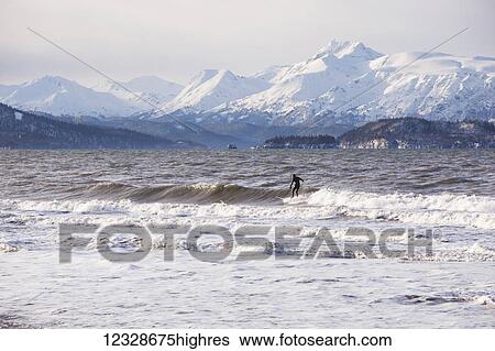 Stock Photograph - Surfer in Kachemak Bay, South-central Alaska; Homer, Alaska, United States of America. Fotosearch