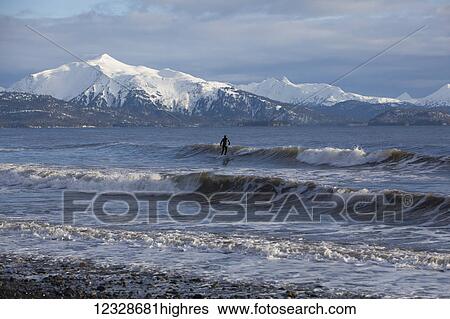 Stock Photograph - Surfer in Kachemak Bay, South-central Alaska; Homer, Alaska, United States of America. Fotosearch