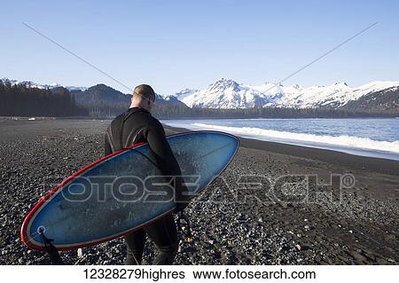 Surfer On The Beach With His Surfboard, Kenai Peninsula Outer Coast, Southcentral Alaska, USA View Large Photo Image Stock Photograph - Surfer On The Beach With His Surfboard, Kenai Peninsula Outer Coast, Southcentral Alaska, USA. Fotosearch