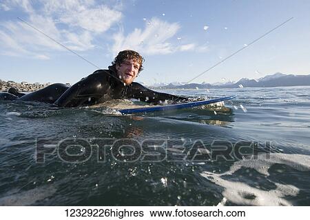Surfer paddles out into the ocean, Southeast Alaska; Yakutat, Alaska, United States of America View Large Photo Image Stock Photograph - Surfer paddles out into the ocean, Southeast Alaska; Yakutat, Alaska, United States of America. Fotosearch