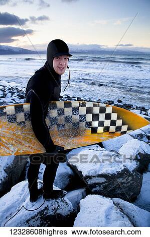 Surfer preparing to surf in winter near Homer, South-central Alaska; Alaska, United States of America View Large Photo Image Stock Photograph - Surfer preparing to surf in winter near Homer, South-central Alaska; Alaska, United States of America. Fotosearch