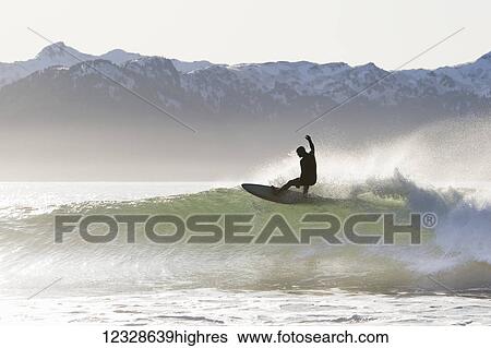 Surfer riding a wave on the Kenai Peninsula Outer Coast, South-central Alaska; Alaska, United States of America View Large Photo Image Stock Photograph - Surfer riding a wave on the Kenai Peninsula Outer Coast, South-central Alaska; Alaska, United States of America. Fotosearch