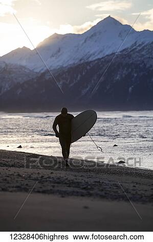 Stock Photograph - Surfer With His Surfboard At Kachemak Bay, Homer Spit, Southcentral Alaska, USA. Fotosearch