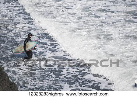 Surfer With Surfboard Enters Waters Of The Kenai Peninsula Outer Coast, Southcentral Alaska, USA View Large Photo Image Stock Photograph - Surfer With Surfboard Enters Waters Of The Kenai Peninsula Outer Coast, Southcentral Alaska, USA. Fotosearch