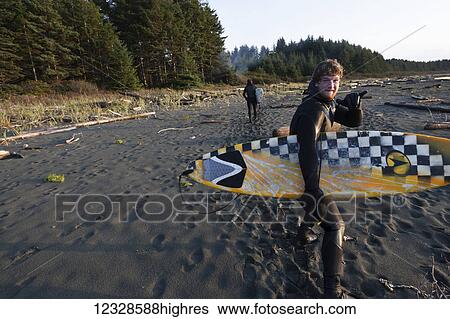 Stock Photograph - Surfers with boards on the beach near Yakutat, Southeast Alaska; Alaska, United States of America. Fotosearch