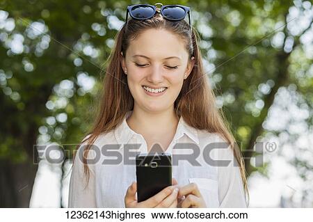 Teenage girl using her smart phone, Woodbine Beach; Toronto, Ontario, Canada View Large Photo Image Stock Photograph - Teenage girl using her smart phone, Woodbine Beach; Toronto, Ontario, Canada. Fotosearch