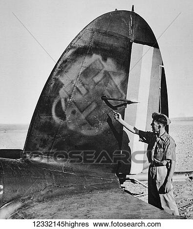 Stock Photograph - The Illustrated London News 1941. World war II. Collaboration between vichy and axis powers, the tail of a German aircraft damaged at Palmyra with Vichy markings painted over with the nazi Swastika. Fotosearch