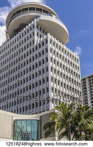 Stock Photograph - The Waikiki Busines Plaza towers over Waikiki near the intersection of Kalakaua and Seaside avenues; Honolulu, Oahu, Hawaii, United States of America. Fotosearch