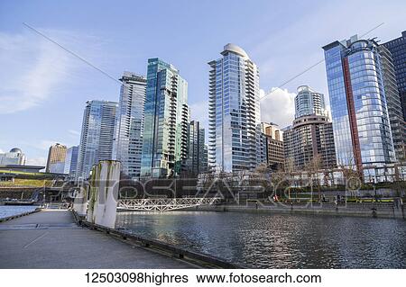 The walking path on the public boat dock in downtown Vancouver along the seawall at the Coal Harbour waterfront neighbourhood with a view of skyrise condo towers and hotels on the skyline; Vancouver, British Columbia, Canada View Large Photo Image Stock Photograph - The walking path on the public boat dock in downtown Vancouver along the seawall at the Coal Harbour waterfront neighbourhood with a view of skyrise condo towers and hotels on the skyline; Vancouver, British Columbia, Canada. Fotosearch