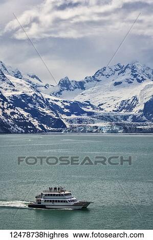 Stock Photograph - Tour boat cruises past Johns Hopkins Glacier in Glacier Bay National Park and Preserve; Alaska, United States of America. Fotosearch