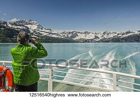 Stock Photograph - Tourist on the tour boat Baranof Wind photographing Glacier Bay National Park and Preserve, Southeast Alaska; Alaska, United States of America. Fotosearch