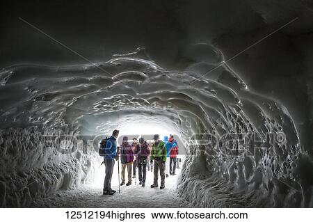 Stock Photograph - Tourists gathering in the ice tunnel at Aiguille du midi summit in summertime, Alps; Chamonix-Mont-Blanc, Haute-Savoie, France. Fotosearch