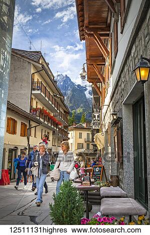 Stock Photograph - Tourists strolling along busy town square; Courmayeur, Aosta Valley, Italy. Fotosearch
