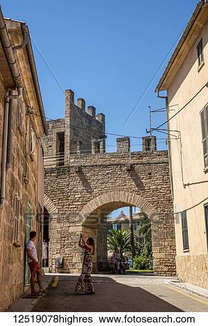 Stock Photograph - Tourists taking photos near Alcudia's Roman wall; Alcudia, Mallorca, Balearic Islands, Spain. Fotosearch