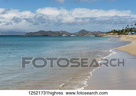 Stock Photograph - Tourists walking along the shore of a Caribbean Island; Nevis, West Indies. Fotosearch