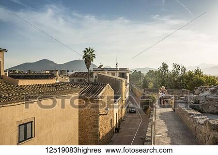 Tourists walking over the city wall; Alcudia, Mallorca, Balearic Islands, Spain View Large Photo Image Stock Photograph - Tourists walking over the city wall; Alcudia, Mallorca, Balearic Islands, Spain. Fotosearch