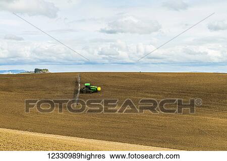 Stock Photograph - Track Tractor Configured With Spraying Booms Spraying Fertilizer On A Garbonzo Bean Seedbed In The Palouse Region Of Eastern Washington; Washington, United States Of America. Fotosearch
