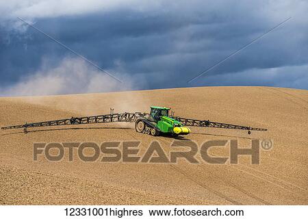 Stock Photograph - Track Tractor Configured With Spraying Booms Spraying Fertilizer On A Garbonzo Bean Seedbed In The Palouse Region Of Eastern Washington; Washington, United States Of America. Fotosearch