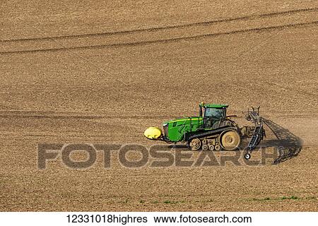 Stock Photograph - Track Tractor Configured With Spraying Booms Spraying Fertilizer On A Garbonzo Bean Seedbed In The Palouse Region Of Eastern Washington; Washington, United States Of America. Fotosearch