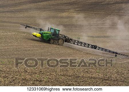 Stock Photograph - Track Tractor Configured With Spraying Booms Spraying Fertilizer On A Garbanzo Bean Seedbed In The Palouse Region Of Eastern Washington; Washington, United States Of America. Fotosearch