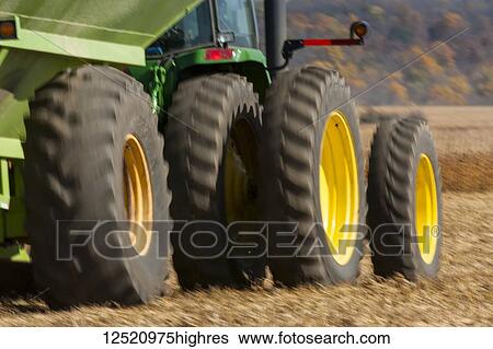Stock Photograph - Tractor and grain wagon move across a field during a soybean harvest; Minnesota, United States of America. Fotosearch