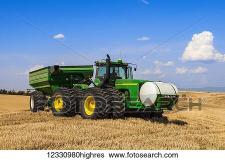 Stock Photograph - Tractor Pulling A Grain Cart During Wheat Harvest In The Palouse Region Of Eastern Washington; Washington, United States Of America. Fotosearch