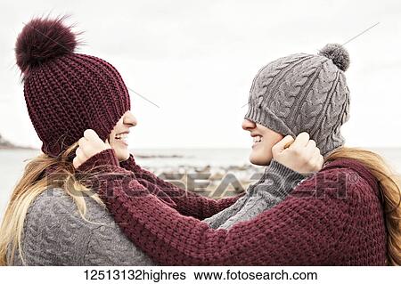 Two friends playing on the beach wearing knit hats and scarves, Woodbine Beach; Toronto, Ontario, Canada View Large Photo Image Stock Photograph - Two friends playing on the beach wearing knit hats and scarves, Woodbine Beach; Toronto, Ontario, Canada. Fotosearch