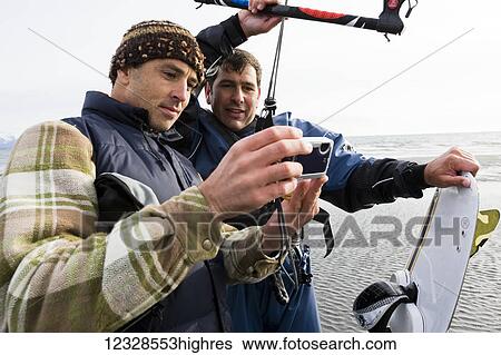Two men review photos on a camera during a kitesurfing class, Kachemak Bay, South-central Alaska; Alaska, United States of America View Large Photo Image Stock Photograph - Two men review photos on a camera during a kitesurfing class, Kachemak Bay, South-central Alaska; Alaska, United States of America. Fotosearch