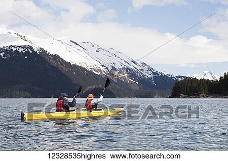 Two sea kayakers in a double sea kayak, Kachemak Bay, Southcentral Alaska; Alaska, United States of America View Large Photo Image Stock Photograph - Two sea kayakers in a double sea kayak, Kachemak Bay, Southcentral Alaska; Alaska, United States of America. Fotosearch