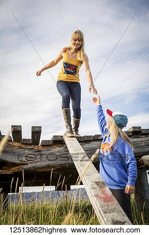 Two sisters explore an old wooden pier near Homer, South-central Alaska; Homer, Alaska, United States of America View Large Photo Image Stock Photograph - Two sisters explore an old wooden pier near Homer, South-central Alaska; Homer, Alaska, United States of America. Fotosearch