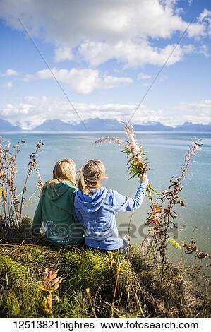 Two women sit on bluff overlooking Kachemak Bay on an autumn day, South-central Alaska; Homer, Alaska, United States of America View Large Photo Image Stock Photograph - Two women sit on bluff overlooking Kachemak Bay on an autumn day, South-central Alaska; Homer, Alaska, United States of America. Fotosearch