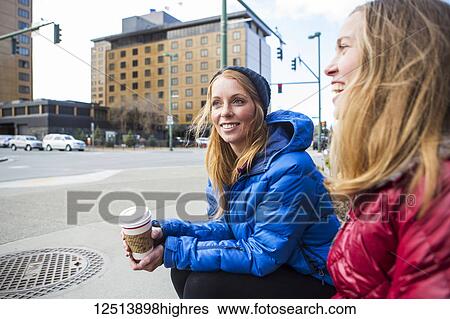 Stock Photograph - Two young women hanging out in downtown Anchorage, South-central Alaska; Anchorage, Alaska, United States of America. Fotosearch