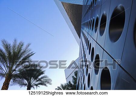 Unique facade of a building with circles in rows along the wall and blue sky with palm trees; Las Vegas, Nevada, United States of America View Large Photo Image Stock Photograph - Unique facade of a building with circles in rows along the wall and blue sky with palm trees; Las Vegas, Nevada, United States of America. Fotosearch