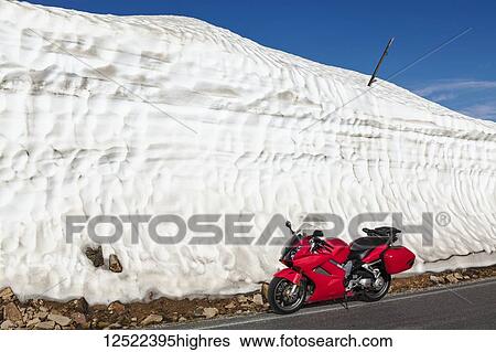 View from the Beartooth Highway of a motorcycle parked along a s0wdrift on the roadside; Cody, Wyoming, United States of America View Large Photo Image Stock Photograph - View from the Beartooth Highway of a motorcycle parked along a s0wdrift on the roadside; Cody, Wyoming, United States of America. Fotosearch