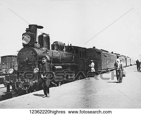 Vintage black and white image of passengers and a worker on the platform of a train station with a passenger train View Large Photo Image Stock Photograph - Vintage black and white image of passengers and a worker on the platform of a train station with a passenger train. Fotosearch