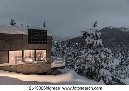 Warm light emanates from a cabin in a snow-covered landscape, solar panels on the roof of the cabin, cool light at dusk casts soft light on distant snow-covered Kenai Mountains, South-central Alaska in winter; Moose Pass, Alaska, United States of America View Large Photo Image Stock Photograph - Warm light emanates from a cabin in a snow-covered landscape, solar panels on the roof of the cabin, cool light at dusk casts soft light on distant snow-covered Kenai Mountains, South-central Alaska in winter; Moose Pass, Alaska, United States of America. Fotosearch