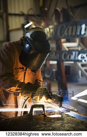Welder And Metal Work Artist Doug Schwiesow Working On A Custom Sign Designed With A Local Artist For The Kenai Peninsula College Kachemak Bay Campus. View Large Photo Image Stock Photograph - Welder And Metal Work Artist Doug Schwiesow Working On A Custom Sign Designed With A Local Artist For The Kenai Peninsula College Kachemak Bay Campus.. Fotosearch