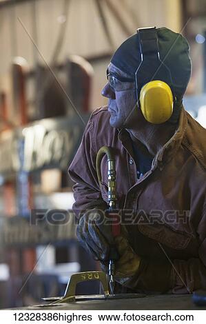 Welder And Metal Work Artist Doug Schwiesow Working On A Custom Sign Designed With A Local Artist For The Kenai Peninsula College Kachemak Bay Campus. View Large Photo Image Stock Photograph - Welder And Metal Work Artist Doug Schwiesow Working On A Custom Sign Designed With A Local Artist For The Kenai Peninsula College Kachemak Bay Campus.. Fotosearch