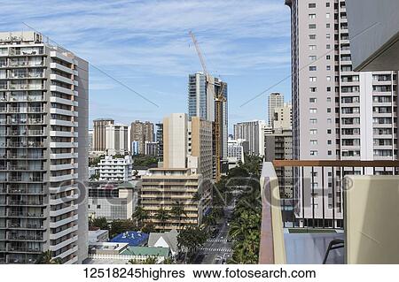 Stock Photograph - Westward view down Kuhio Avenue from a hotel balcony in Waikiki; Honolulu, Oahu, Hawaii, United States of America. Fotosearch