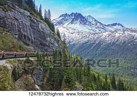 Stock Photograph - White Pass Railroad transports tourists on ride out of Skagway Alaska into Canada and returns; Skagway, Alaska, United States of America. Fotosearch
