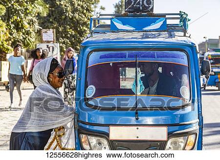 Woman by an auto rickshaw talking to the driver through the window; Wukro, Tigray Region, Ethiopia View Large Photo Image Stock Photograph - Woman by an auto rickshaw talking to the driver through the window; Wukro, Tigray Region, Ethiopia. Fotosearch