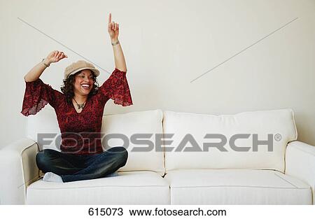 Woman celebrates on sofa View Large Photo Image Stock Image - Woman celebrates on sofa. Fotosearch