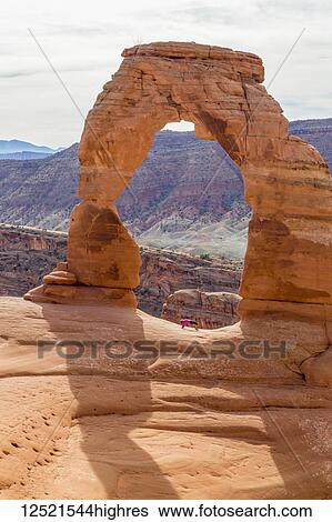Stock Photograph - Woman doing yoga pose under Delicate Arch, Arches National Park; Moab, Utah, United States of America. Fotosearch