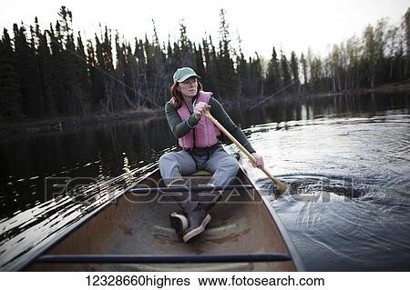 Stock Photograph - Woman in a canoe at Swanson Lake, Kenai Peninsula, South-central Alaska; Alaska, United States of America. Fotosearch