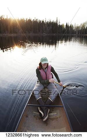 Stock Photograph - Woman in a canoe at Swanson Lake, Kenai Peninsula, South-central Alaska; Alaska, United States of America. Fotosearch